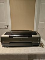 Front view of EPSON Stylus Photo R1800 printer showing original closed top cover and front panel with power button and logo visible
