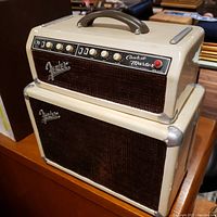 Two-piece ceramic cookie jar set replicating a vintage Fender Band Master amplifier. Top piece includes handle and amp control panel labeled 'Cookie Master'. Lower piece simulates speaker cabinet with textured front and Fender logo.