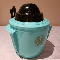 Side view of the vintage Hankscraft electric steam vaporizer humidifier showing turquoise base, black top, and electrical cord.