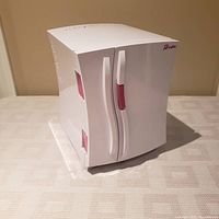 White Proctor Silex mini fridge front and side angled view showing design, dual white and pink handles, and brand logo