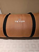 Large brown carry bag with Teton Sports logo and black carrying straps.