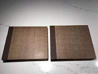 Two large brown vintage album cases with cloth spines for holding 78 RPM records on a white surface.