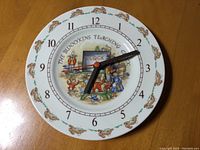 Front view of the ceramic Bunnykins teaching clock, showing detailed bunny illustrations around the rim and central teaching scene, clock hands positioned near 4:10.