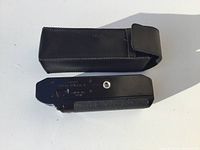 Canon Power Winder A with black leather case on white background, showing overall condition and size.