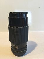 Front and side view of Canon Zoom Lens FD 50-135mm aperture f/3.5 with zoom and focus rings visible.