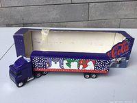 Coca Cola diecast transport truck with trailer and original box, showing side profile.