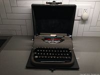 Oliver Monitor portable typewriter in open position showing full keyboard and ribbon.