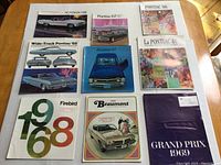 Lot overview showing all eight Pontiac brochures arranged neatly on table.