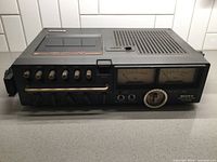 Front angle view of Sony cassette-corder showing control buttons, VU meters, dial and cassette compartment.