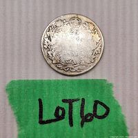 Reverse side showing "25 CENTS" denomination, year 1918 under crown, maple leaf wreath and coin wear.