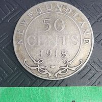 Close-up of reverse side of 1918 Newfoundland 50 cents silver coin showing date, denomination, and decorative scrolls with signs of wear and tarnish.