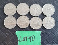 Eight Canadian 5 cent coins from 1940, 1946, and 1947 displayed, showing the beaver design and dates on each coin.