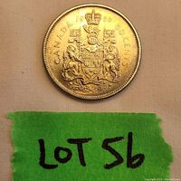 Close-up photo of the 1966 Canadian 50 cent coin with coat of arms visible, showing some surface wear and signs of aging.