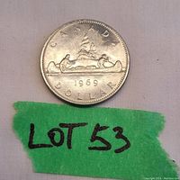 Front side of the 1969 Voyageur Canada dollar coin showing the canoe with two men paddling, trees in the background, and inscriptions.