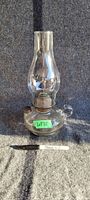 Photo of full vintage finger oil lamp showing the entire lamp with clear glass base, finger loop, metal filler cap, and tall chimney.