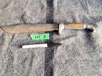 Full length of large Mexican bowie knife next to a marker for scale, showing the blade and wooden handle with eagle head pommel.
