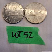 Front side of two 1985 Canada dollar coins showing the Voyageur canoe design.