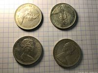 Four 1966 Canadian silver dollar coins with obverse side showing Queen Elizabeth II portrait.