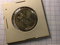 Reverse side showing classical figure of victory holding Olympic torch with inscription and denomination