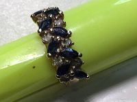 Ring top view on green pen showing marquise sapphires and round diamonds