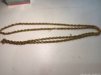 Full view of the 44-inch gold-tone chain laid out on a flat surface