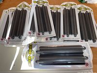 Multiple unopened packages of Bachmann E-Z Track straight track sections made from steel alloy, displayed on table.