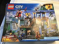 Front image of Lego City Mountain Police Headquarters box showing set number, age range, and main features like helicopter, police ATV, building, and figures.