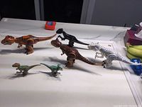Six LEGO Jurassic World dinosaur figures arranged on countertop