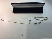 Photo showing full set: necklace, bracelet, pair of earrings, and jewelry box lid.