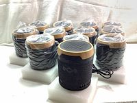 12 House of Marley Chant Mini wired speakers wrapped in plastic, shown grouped with foam bases, displayed on a white surface