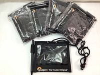 Five Lowepro branded black lanyard ID card holders in plastic packaging laid out with one holder outside the packaging showing front view and pen loop on side