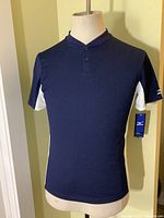 Front view of navy blue short sleeve Mizuno baseball shirt on mannequin, showing white side panels and tag attached.