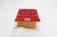 Red Wheelock ET-1080 speaker in front view on top of its box plus a papersheet with instructions and warnings.