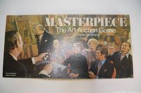 Photo of the Masterpiece board game box top showing artwork of an auction scene.