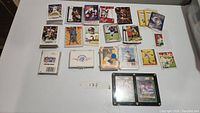 Assorted trading cards including Pokemon, NFL Proset, Starting Lineup, Ty Cobb, Coca-Cola and other sports cards arranged on table.