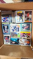 Box containing stacks of loose hockey cards showing a variety of players, mainly from the 1980s era.