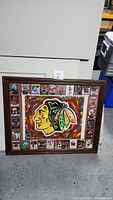 Full view of framed painting with Chicago Blackhawks logo and surrounding hockey cards.