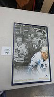 Full view of framed poster showing Wendel Clark and other hockey players/staff, with Oakville grand opening text at bottom.