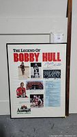 Framed poster with Bobby Hull images and signature, displayed for identification.