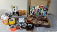 Photo of overall lot showing various tapes, paint jars, wooden box with stamps and sewing items, and other supplies