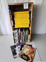 Wooden shelf packed with vintage National Geographic magazines and other magazines like Time, People, and Cream on lower shelves, with some comics
