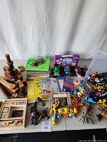 Overview photo with wooden animal blocks, books by Roald Dahl and others, small action figures, and a collection of mixed toy cars and figurines.