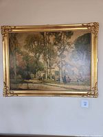 Front view of the original oil painting showing the landscape scene, signature, and ornate gold frame.