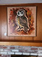 Full view of the framed owl painting with wood panel wall background.