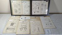 Full set of vintage purse patent prints displayed flat on a surface, including two in frames.
