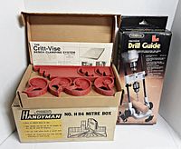 Photo showing Critt-Vise Bench Clamping System red plastic clamps in box on top of Stanley Handyman No. H114 Mitre Box original packaging and General Precision Drill Guide box.