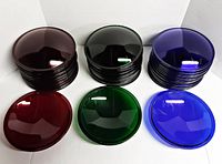 Three stacks of red, green, and blue glass lenses with one of each color laid in front
