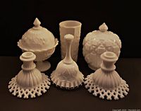 Front view showing full lot with two candle holders, bell, two covered candy jars, and tall tumbler against dark background