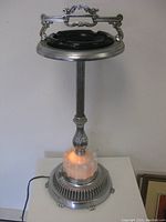 Front view of illuminated chrome ashtray stand on table