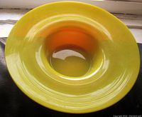 Top and angled views of the yellow to orange ombre art glass bowl, showing glossy finish and smooth curved form.
